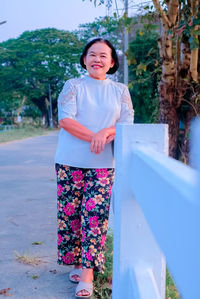 Portrait of smiling woman standing against plants