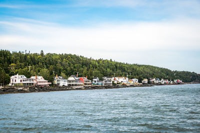 Scenic view of sea by buildings against sky