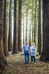 Retired couple walking in nature, enjoying their freedom.