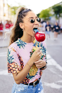 Cheerful lady having fun enjoying sweet candy apple