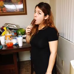 Beautiful young woman drinking water at home