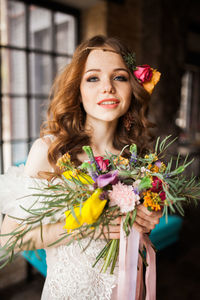 Portrait of young woman with red flower