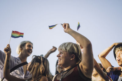 Happy non-binary person with friends enjoying in lgbtqia rights parade