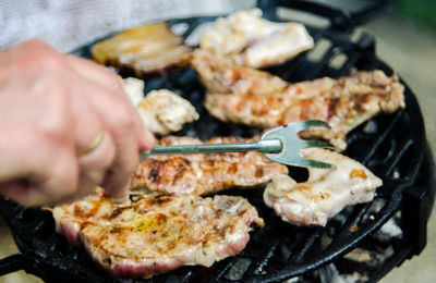 Close-up of man preparing food on barbecue grill