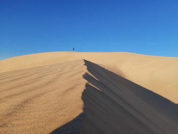 Scenic view of desert against clear blue sky