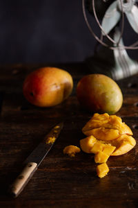 Close-up of fresh organic mangoes with knife on table