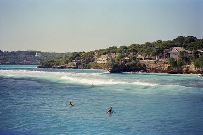 Scenic view of surfers somewhere in nusa lembongan, indonesia. shot on 35mm kodak portra 400 film.
