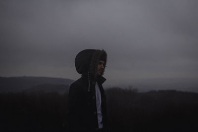 Man with umbrella against sky