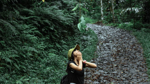 Woman standing amidst trees in forest