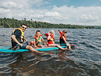 People enjoying in water against sky