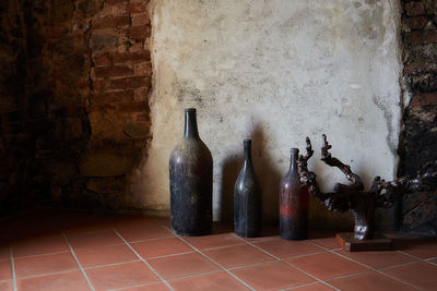 Bottles on table against wall