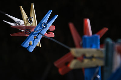 Close-up of multi colored clothespins toy against black background