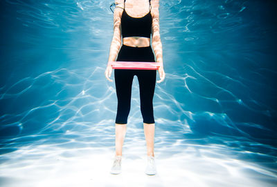 Full length of woman standing in swimming pool