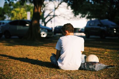 Rear view of man sitting on car