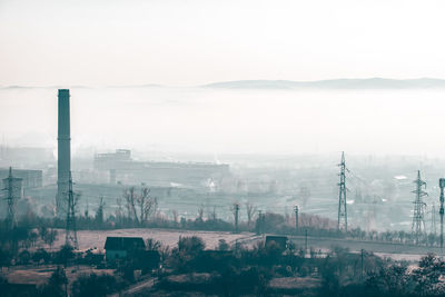 Aerial view of factory against sky in city