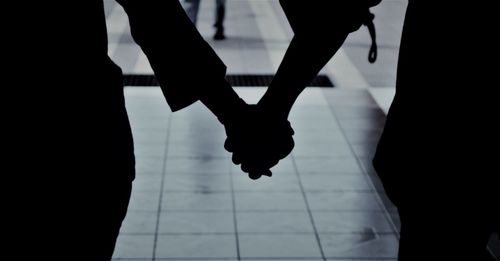 Low section of silhouette people standing on tiled floor