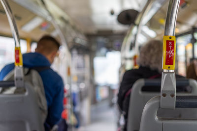 Bus interior in circulation with the stop button in the foreground on a blurred background.