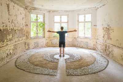 Full length of man standing by window