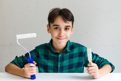 Portrait of young man holding thermometer
