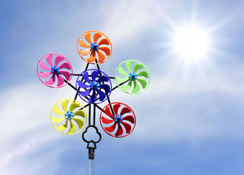 Low angle view of colorful pinwheel toy against sky during sunny day