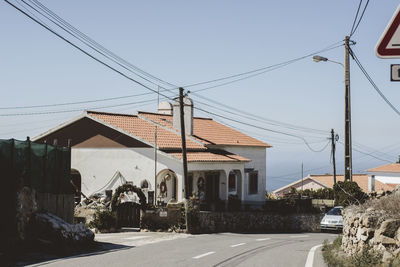 Houses by street against sky in city