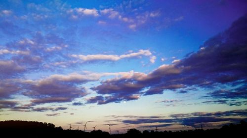 Silhouette of trees against cloudy sky