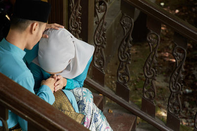 High angle view of couple sitting on staircase outdoors