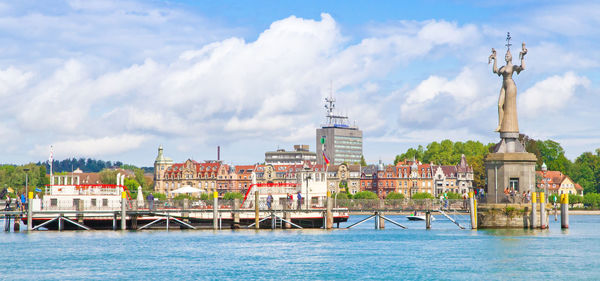 View of buildings in sea against cloudy sky