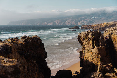 High angle view of rocky beach against sky