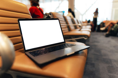 Midsection of woman using laptop at table