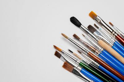 Close-up of make-up brushes over white background