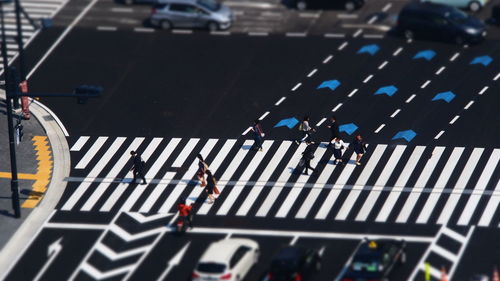 Tilt-shift image of people and cars on street