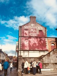 Rear view of people walking on historical building