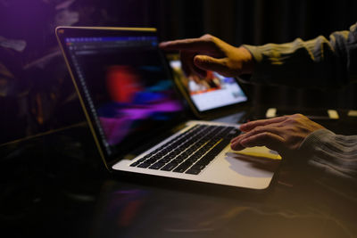 Midsection of man using laptop on table