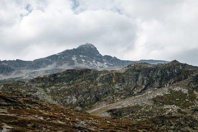 Scenic view of rocky mountains against cloudy sky