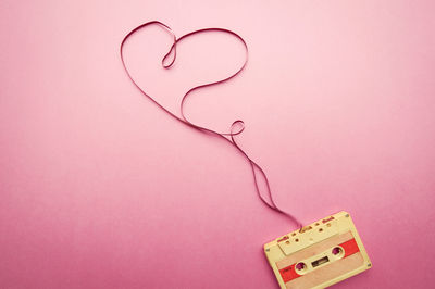 Close-up of audio cassette on pink table