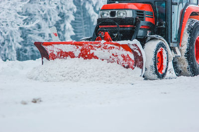 Construction vehicle cleaning snow on road