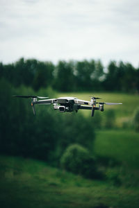 Airplane flying over land against sky