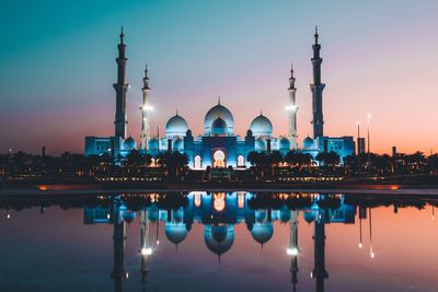 Reflection of illuminated buildings in city at dusk