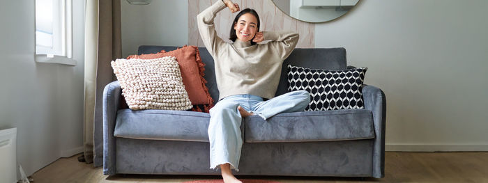 Portrait of woman sitting on sofa at home