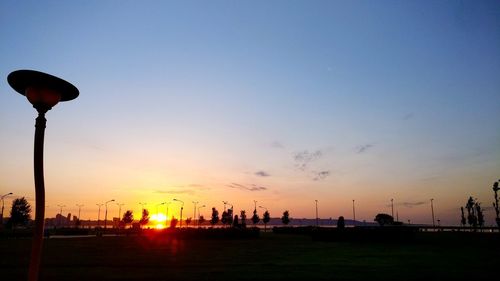 Silhouette street light against sky during sunset