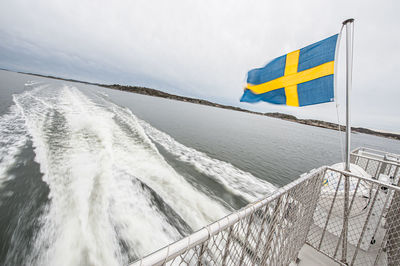 Flag by sea against sky