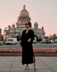 Rear view of woman standing against historic building