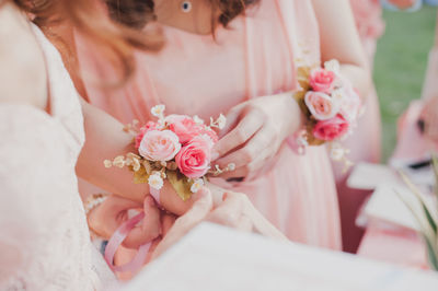 Midsection of bride wearing flower