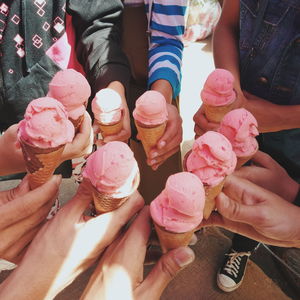 Midsection of people holding ice cream