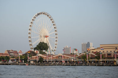 Ferris wheel in city against clear sky