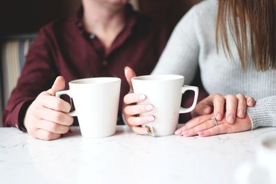 Midsection of woman drinking coffee