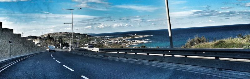 Road by sea against sky in city