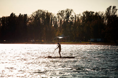 Man standing in lake against sky