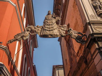 Low angle view of statue against building in city